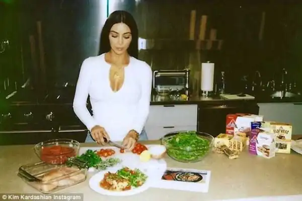Kim K. stuns in plunging white top asshe makes Italian Chicken Cacciatore in the kitchen